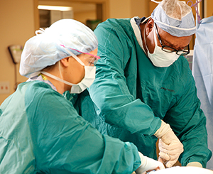 Proveedores de atención médica haciendo una cirugía en el quirófano.